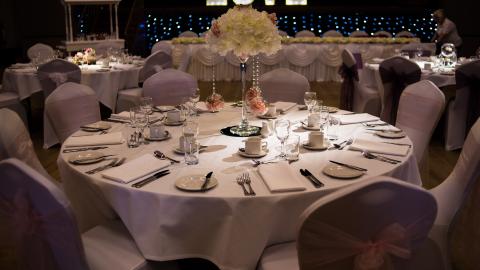 An image of a table decorated for a wedding with love in big letters lit up behind it