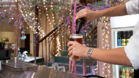 An image of someone pouring a beer into a glass