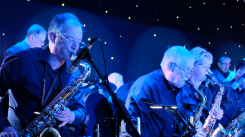 Band members of the Northern Swing Orchestra play various instruments on stage. 