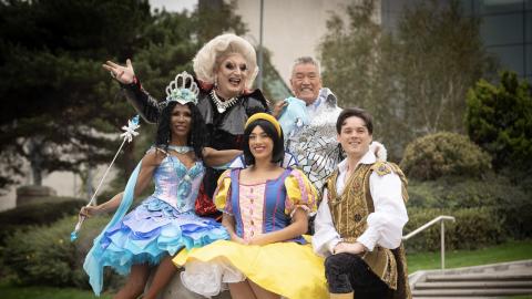 Five cast members of Snow White pantomime in brightly coloured outfits.