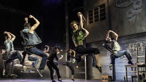 Men jumping in the air in front of a garage