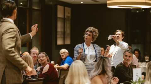 Three actors take part in an interactive dining experience as the audience watches.