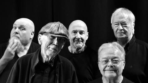 A black and white image of five men in a band.