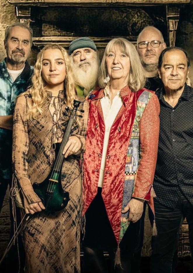 Five members of music group Steeleye Span stand together in the centre of the frame.
