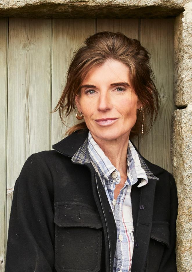 A close up of TV personality and farmer Amanda Owen leaning against an outside door.