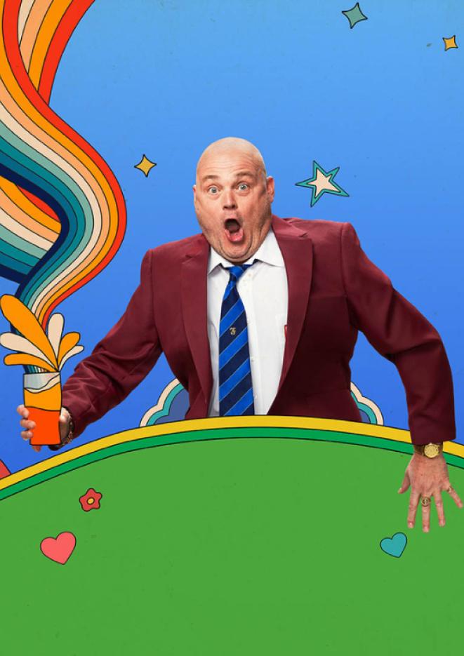 TV personality and comedian Al Murray wears a burgundy jacket and blue tie, stood behind a graphic of a green hill.