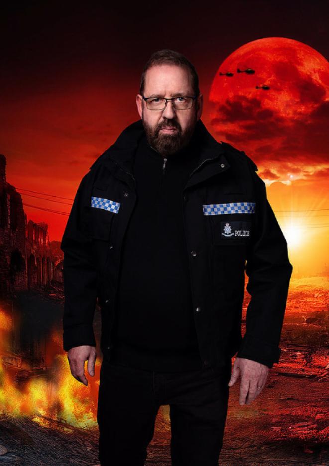 Comedian Alfie Moore wearing a police uniform walking in front of a graphic of a planet on fire with a giant red sun in the background.