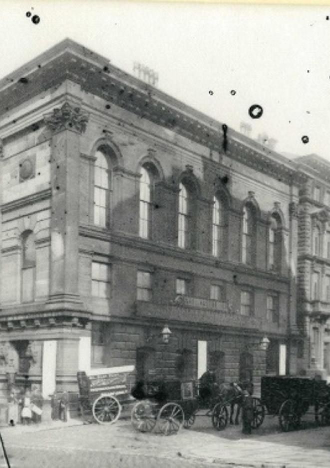 A black and white photograph of the exterior of St George's Hall with horse and cart outside.