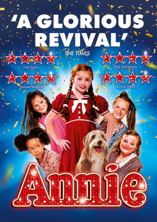 Young cast members of the show Annie stand against a blue background.