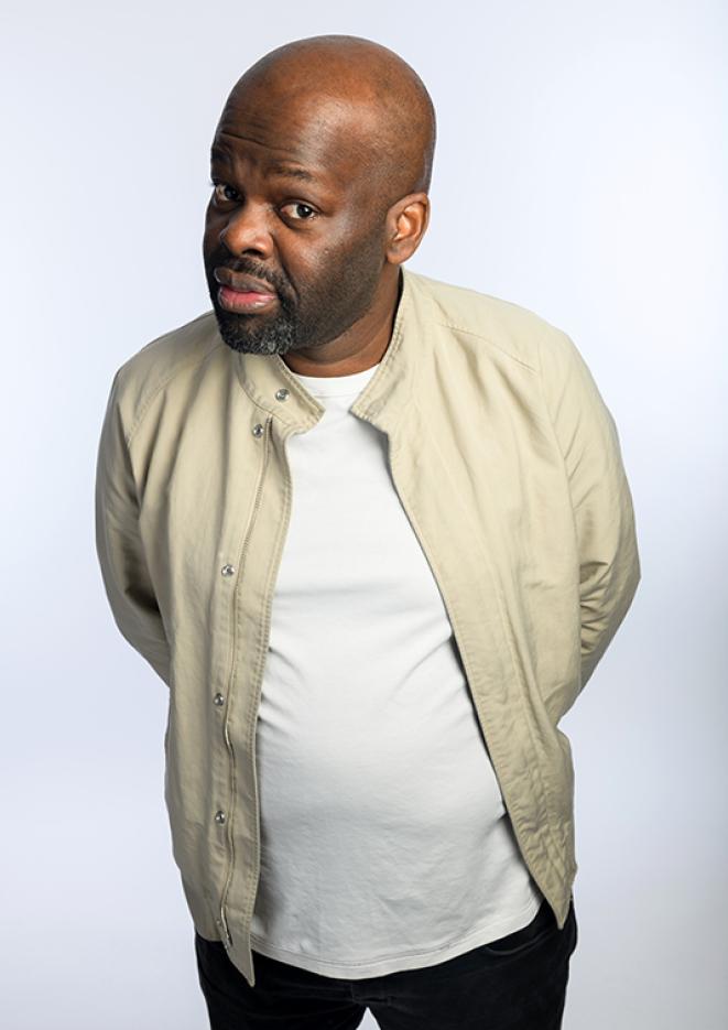 Comedian Daliso Chaponda stood against a plain, white background.