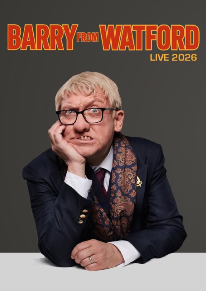 Portrait of a character created by comedian Alex Lowe sits against a grey background wearing a deep blue suit, text above reads Barry From Watford.