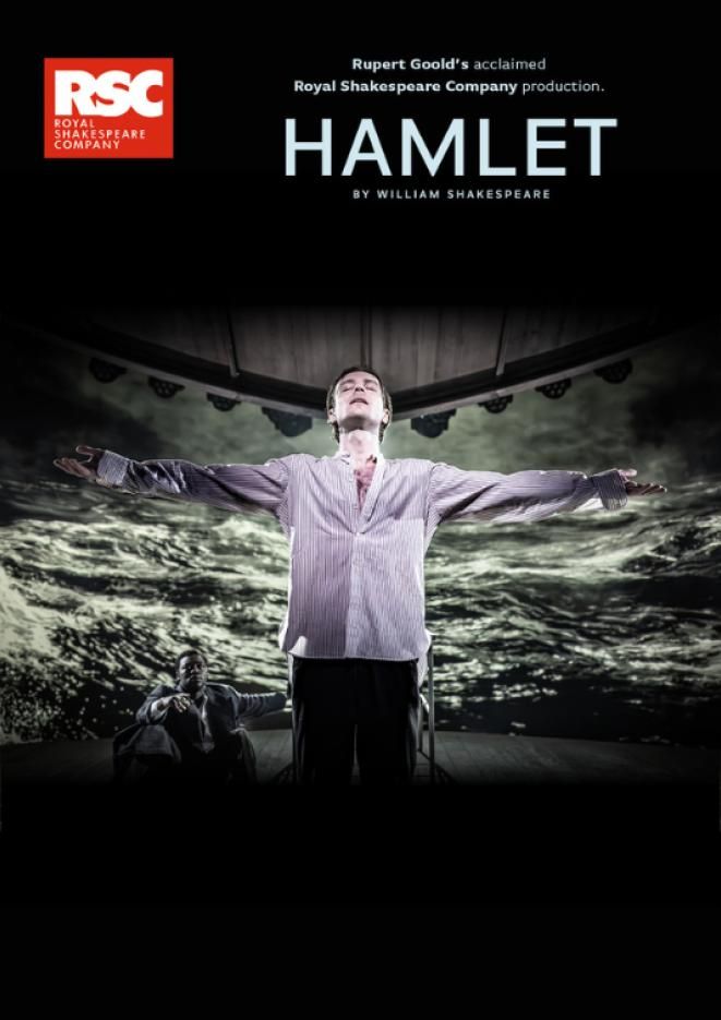 A black background with a man in the centre stood with his arms raised out to the side and a screen with waves behind him.