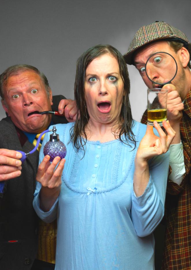 A woman in a blue dress and black mascara running down her face holds a drink and some perfume and pulls a face at the camera. Two men in detective gear stands behind her inspecting the objects.