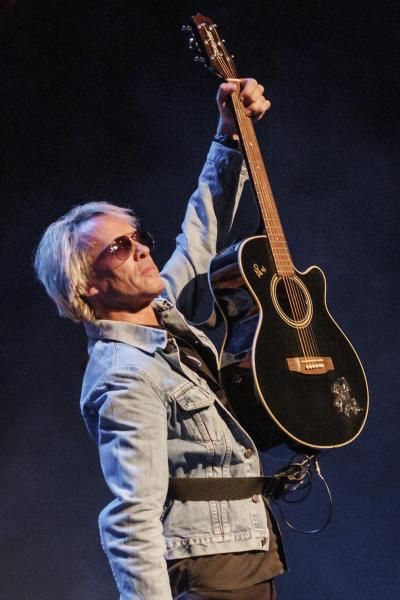 Close up of a musician holding a guitar in the air as part of The Bon Jovi Experience.